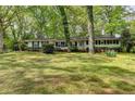 Charming one-story home with black shutters surrounded by mature trees and a spacious front lawn at 2963 Williams Pl, Snellville, GA 30078