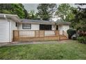 A charming home featuring a white brick facade, black trim, and a lovely, light wood slat front porch at 3207 Bobbie Ln, Decatur, GA 30032