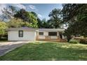 Charming single story house with a large front yard and a freshly painted white brick facade with black trim at 3207 Bobbie Ln, Decatur, GA 30032