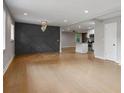 Spacious open concept living room with hardwood floors, a decorative wall, and a view into the kitchen at 3207 Bobbie Ln, Decatur, GA 30032