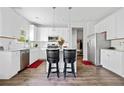 Modern kitchen with white cabinets, stainless steel appliances, and a stylish breakfast bar at 5780 Winding Lakes Dr, Cumming, GA 30028