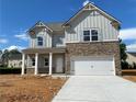 Charming two-story home featuring stone accents, gray siding and a spacious two-car garage at 4556 Sweetlake Sw Ct, Mableton, GA 30126