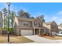 Two-story home with brick and siding, a two-car garage, landscaped yard, and inviting curb appeal at 4531 Claiborne Ct, Duluth, GA 30096