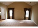 Bright living room featuring carpet and large windows adorned with decorative curtains at 115 Catlyn Ct, Riverdale, GA 30296