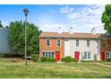 Exterior shot of charming townhomes with manicured lawns beneath a bright sky at 197 Holcomb Ferry Rd, Roswell, GA 30076