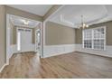 Light-filled dining room with elegant white wainscoting and hardwood floors at 3401 Ravensworth Trce, Kennesaw, GA 30144