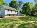 Large backyard with a lush green lawn, surrounded by mature trees for added privacy at 1835 Penrose Ct, Powder Springs, GA 30127