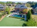 Aerial view of the home's backyard featuring a swimming pool with an adjacent manicured lawn and lush landscaping at 2199 Tayside Nw Xing, Kennesaw, GA 30152