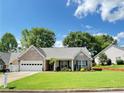 Charming single-story home features a brick facade, well-manicured lawn, and attached garage at 4025 Mcdowell Dr, Acworth, GA 30101