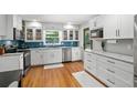 Renovated kitchen featuring white cabinets, stainless steel appliances, and blue backsplash at 4841 Village North Ct, Atlanta, GA 30338