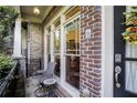 Inviting front porch with brick detail, an outdoor seating area and view of the home's entryway at 225 Mystic Ridge Hl, Sandy Springs, GA 30342