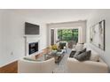 Bright living room with a fireplace, wood floors, and a balcony overlooking lush greenery at 23310 Plantation Ne Dr, Atlanta, GA 30324