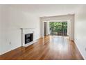 Bright living room with a fireplace, wood floors, and a balcony overlooking lush greenery at 23310 Plantation Ne Dr, Atlanta, GA 30324