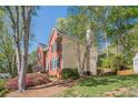 Side view of a two-story home with brick and siding, black shutters, and a well-kept lawn at 2566 Garrison Sw, Marietta, GA 30064
