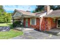 Close-up view of a quaint brick home featuring a covered front porch at 5690 Abbotts Bridge Rd, Johns Creek, GA 30097