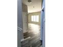 Inviting hallway with wood-look flooring, leading into a sunlit living area at 4346 Traipse Path, Ellenwood, GA 30294