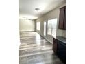 Open living room featuring wood-look floors that connect to the kitchen area at 4346 Traipse Path, Ellenwood, GA 30294