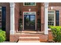 Welcoming entrance with double doors, brick pillars, and manicured greenery at 605 Tatum Ct, Alpharetta, GA 30022