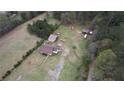 Aerial view showing the home, outbuildings and surrounding wooded acreage at 1277 Bethany Rd, Covington, GA 30016