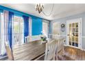 Bright dining room features hardwood floors, a rustic table set, and lots of natural light from the windows at 208 Wellington Walk, Douglasville, GA 30134