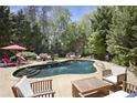 Inviting backyard oasis featuring a private pool surrounded by lush landscaping and comfortable patio seating at 3025 Greenfield Dr, Marietta, GA 30068