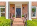 Inviting front entrance featuring brick steps, decorative columns, and stylish black front door at 1038 Huntcliff, Atlanta, GA 30350
