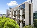 Exterior view of a high-rise building with expansive windows, multiple balconies, and mature trees in the foreground at 145 15Th Ne St # 435, Atlanta, GA 30309