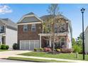 Two-story brick home featuring an attached two-car garage, landscaped yard, and a cozy front porch at 244 Walnut Ridge Rd, Canton, GA 30115