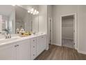 Modern bathroom with double vanities, sleek countertops, and a spacious walk-in closet for ample storage at 2706 Sw Riverpine Lot 176 Sw Trl, Atlanta, GA 30331