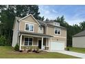 Charming two-story home with a manicured lawn, a covered front porch, and attached two car garage at 2706 Sw Riverpine Lot 176 Sw Trl, Atlanta, GA 30331