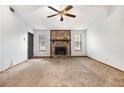 Spacious living room with a stone fireplace, neutral carpet, and abundant natural light from multiple windows at 285 Independence Dr, Jonesboro, GA 30238