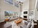 Bright living room with soaring ceilings, fireplace, built-in shelves, and stylish modern furniture at 400 Icicle Ct, Hampton, GA 30228
