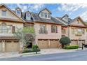 Charming brick townhome featuring a two-car garage, and mature landscaping at 6273 Clapham Ln, Johns Creek, GA 30097
