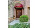 Elegant entryway featuring a stained wood double door and a decorative red awning at 6273 Clapham Ln, Johns Creek, GA 30097