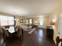 Open-concept living room and dining area featuring hardwood floors, a large window and tasteful decor for comfortable living at 985 Forest Knoll Court, Lithia Springs, GA 30122