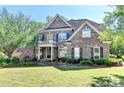 Lovely brick home with a spacious front yard and mature trees offering curb appeal at 1806 Royal Troon Ct, Duluth, GA 30097