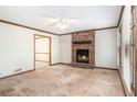 A living room features a brick fireplace, a ceiling fan, and neutral walls at 495 Buttercup Trl, Lawrenceville, GA 30046