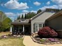 Beautiful home featuring blooming flowerbeds, mature landscaping, and inviting front porch with seating at 201 Aster Ct, Canton, GA 30114