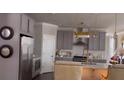 Charming kitchen featuring gray cabinets, stainless steel appliances, white backsplash and quartz countertops at 1179 Bennett Creek Overlook, Suwanee, GA 30024