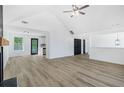 Spacious living room with luxury vinyl flooring, vaulted ceilings, fireplace, and a view of the kitchen at 3487 Creekview Dr, Rex, GA 30273