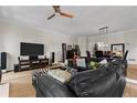 Spacious living room with hardwood floors, large leather couch, TV, and neutral walls at 403 S River Farm Dr, Alpharetta, GA 30022