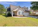 Charming home featuring a two-car garage, stone accents, dormer windows, and a well-manicured lawn at 704 Williamsburg Ct, Villa Rica, GA 30180