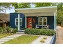 Inviting blue bungalow featuring a covered porch with seating, an orange front door, and professional landscaping at 830 Belgrade Ne Ave, Atlanta, GA 30306
