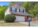 Two-story home with brick and vinyl siding, featuring a two-car garage and a neatly maintained lawn at 395 Anvil Way, Austell, GA 30168