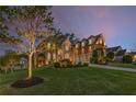 Exterior dusk shot of a brick and stone home with beautiful lawn and landscaping features at 895 Ovalene Sw Ln, Marietta, GA 30064