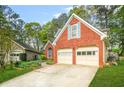 Attractive brick home featuring a two-car garage, a well-maintained lawn, and mature trees at 782 Ridgeland Trl, Clarkston, GA 30021