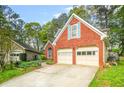 Attractive brick home featuring a two-car garage, a well-maintained lawn, and mature trees at 782 Ridgeland Trl, Clarkston, GA 30021