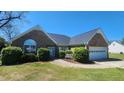 Beautiful brick home featuring an attached garage, well-manicured shrubs, and front yard bench at 116 Ridge Xing, Temple, GA 30179