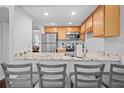 Modern kitchen featuring granite countertops, stainless steel appliances, and breakfast bar seating at 69 Country Place Ct, Alpharetta, GA 30005