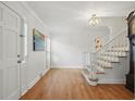Inviting foyer with hardwood floors, staircase, and natural light streaming in at 7000 Hunters Knl, Atlanta, GA 30328